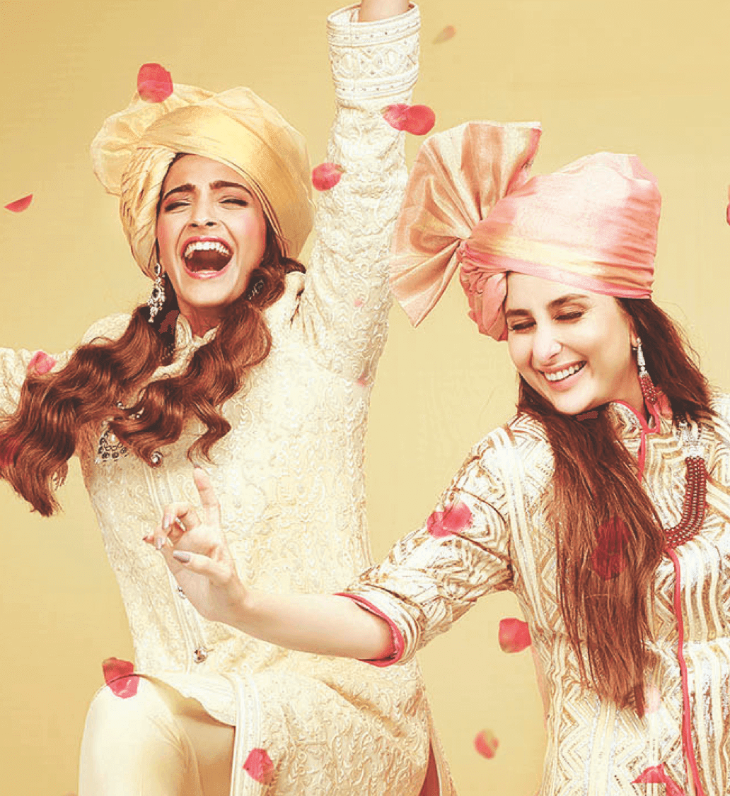 Two women in vibrant traditional attire happily participating in a cultural celebration.