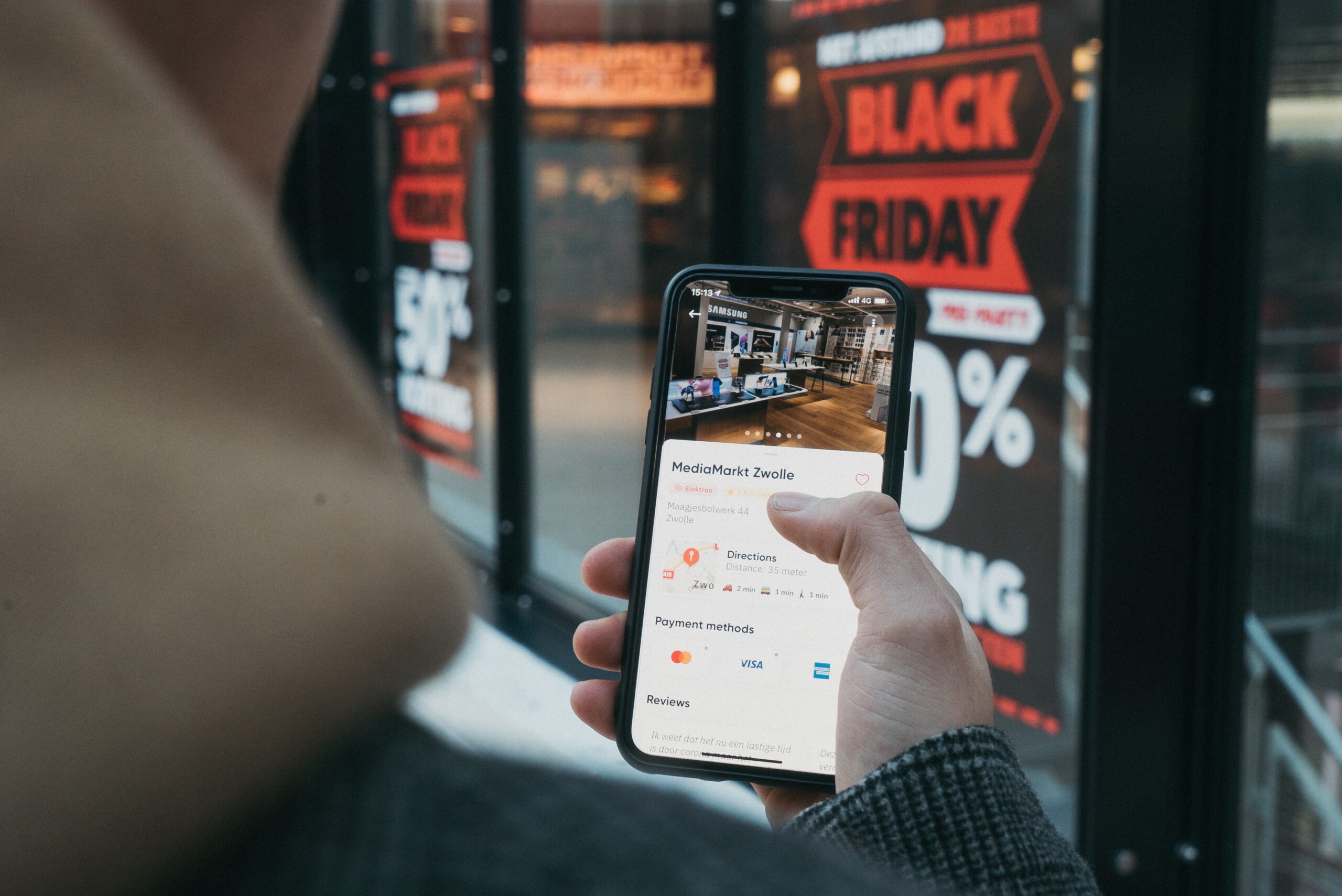 A hand holding a smartphone depicting the online website for a business.