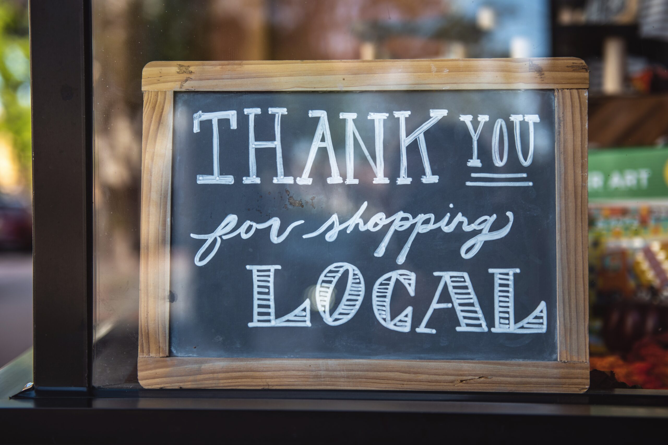 A chalkboard reading the words "Thank you for shopping local"